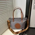 Sac fourre-tout gris en nylon avec poignées en cuir marron et bandoulière réglable - Petit / Gris clair