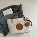 Chic cream tote bag with brown straps and cute plush bear charm for daily use - Large / White Large With Pendant