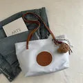 Light blue nylon tote bag with brown leather handles and a plush bear pendant - Large / Light Blue Large With Charm