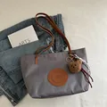 Gray nylon tote bag with brown straps and plush bear pendant in a stylish setting - Large / Dark Gray Large With Charm