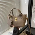 Taupe draagtas met lychee textuur, gouden draaislot en een schattige hondenhanger - Khaki