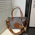 Gray tote bag with brown handles and a bear charm on a minimalist indoor background - Small / Dark Gray Small With Charm