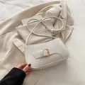 Bolso de hombro beige con forma de media luna, correa decorativa y hebilla dorada - Blanco