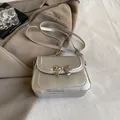 Chic silver crossbody bag for women featuring a metallic bow detail and a flap design - Silver