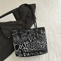 Schwarze Tragetasche mit weißen Graffiti-Mustern und Katzenprints auf minimalistischem Grund - Schwarz
