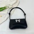 Classic black underarm shoulder bag featuring woven texture and silver bow buckle - Black