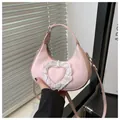 Detailed close-up of pink hobo bag with a white lace heart and smooth PU texture - Pink