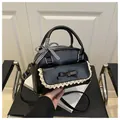 Detail der schwarzen Handtasche mit weißem Spitzenbesatz und kariertem Band am Griff - Schwarz