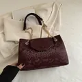Deep burgundy snake-embossed shoulder bag with golden chain strap for women - Red