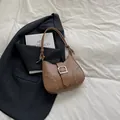 Brown leather shoulder bag with circular cut-outs and knot detail on white background - Khaki