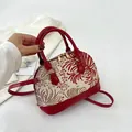 Red shell-shaped handbag with floral embroidery and adjustable strap - Red