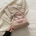 Pink crossbody bag with lace bow decoration and plaid ribbon on beige blazer - Pink
