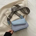 Light blue crossbody bag with woven texture, wide geometric strap and gold hardware - Blue