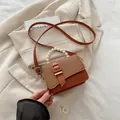 Brown PU and woven shoulder bag with pearl handle and golden buckle strap detail - Brown