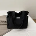 Grande borsa tote in tela nera con etichetta fashion e coulisse per l'uso quotidiano - Nero