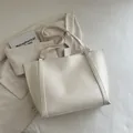 Minimalist beige tote bag in premium faux leather with slim shoulder straps for daily use - White