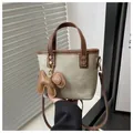 Détail du sac seau en toile vert sauge avec poignées en cuir et breloque petit chien - Avec Pendentif / Marron et Kaki