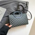 Chic black square handbag with M-pattern monogram and unique circular metal ring handle - Black