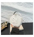 Modern white round crossbody bag with raised SM letter detail and gold dual zipper - White