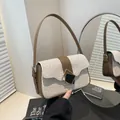 Straw-woven crossbody bag with brown faux leather trim and a golden buckle closure - Brown