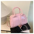 Pink vintage Boston handbag with dual front pockets and adjustable crossbody strap - Pink