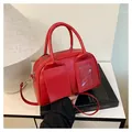 Vintage style red Boston handbag with dual top handles and long shoulder strap in faux leather - Red
