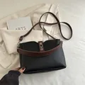 Borsa a secchiello in pelle nera con tracolla marrone e chiusura girevole in argento - Nero