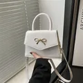 Elegant white square handbag with golden bow detail and slim shoulder strap for women - White