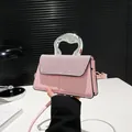 Pink crossbody bag with sparkling rhinestones and a unique silver twisted handle - Pink
