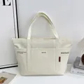 Minimalist cream canvas tote bag with black typography and red side label detail - Off White
