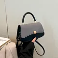 Elegante Handtasche aus schwarzem Leder mit grauer Stoffklappe und Goldverschluss - Schwarz