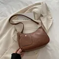 Minimalistische bruine halvemaanvormige tas van kunstleer met gouden metalen gesp - Bruin