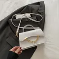 White crocodile texture mini box bag with gold chain and top handle on gray suit - White