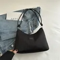 Borsa a secchiello nera plissettata con tracolla a nodo e placchetta logo frontale - Nero