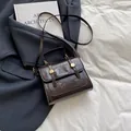 Borsa a tracolla retrò marrone scuro con fibbie dorate e stelle su sfondo di un blazer - Marrone
