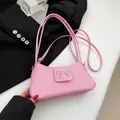 Bolso baguette rosa con detalle de lazo metálico plateado y textura fina - Rosa