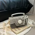 Chic grey denim crossbody bag with white handles and pearl bow charm accessory - White With Pendant