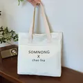 White minimalist canvas tote bag featuring black letter print and large front pocket - Rice White (No Pendant)