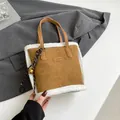 Braune Wildleder-Beuteltasche mit weißem Kunstpelz-Besatz und zwei Handgriffen - Mit Anhänger / Braun