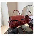 Detail of burgundy wine-red crossbody bag with chocolate square embossing and gold hardware - Red