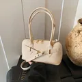 Chic beige woven textured pillow bag with gold hardware and slim handles - Beige