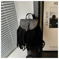 Detalle de mochila bohemia negra con textura de ante y flecos largos decorativos - Negro