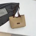 Minimalist beige tote bag with brown straps and fashion label in a modern lifestyle setting - Khaki