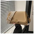Detail of lychee pattern leather texture and gold circular twist-lock on a khaki bag - Khaki