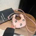 Pink half-moon crossbody leather bag featuring bold silver sphere rivets and a slim strap - Pink