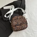 Fashionable leopard print crossbody bag with white adjustable canvas strap on black blazer - Brown