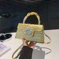 Sac à main doré avec embossage crocodile, boucle strass et poignée plissée - Doré