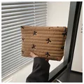 Close-up of quilted makeup bag in tan fabric featuring delicate black bow embroidery - Khaki