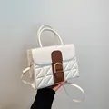 White quilted handbag with brown strap and gold buckle in a stylish 2024 fashion design - White