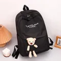 Minimalist black backpack with white typography and a cute plush bear charm accessory - Black